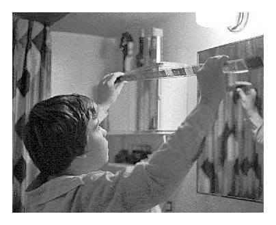 Nile looking at wet negatives above the bathroom sink Looking at negatives